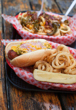 Hot dog with red onions, cheese, relish and curly fries