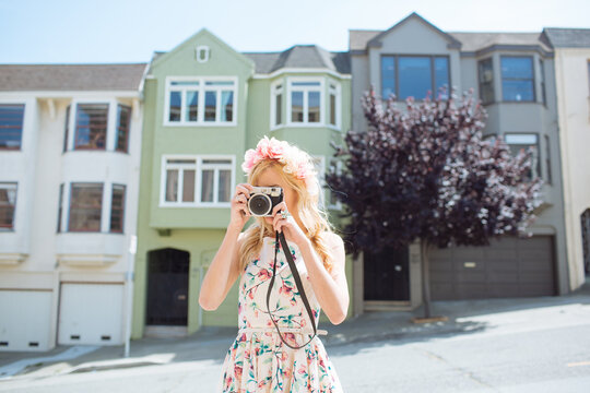 Young woman taking pictures with a vintage camera