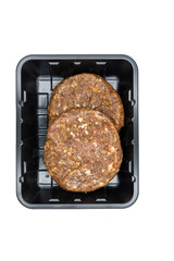 Raw burger meat in a black plastic package isolated on white background, top view.