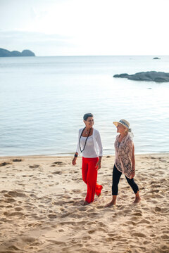 Senior Girlfriends Strolling a Tropical Beach