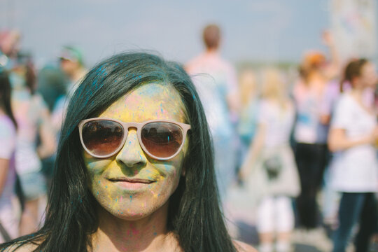 portrait of colorfully painted smiling woman with sunglasses