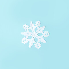 White Snowflake cut from paper on blue background. A traditional Christmas arts and crafts easy diy project. Banner for your site, flyer, voucher, coupon, winter holiday minimal concept