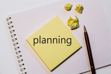 planning written on notepad with space. The word planning. Office, colored paper, pen. Marketing concept.