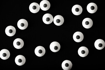 Halloween background, many white bulged eyes in the dark