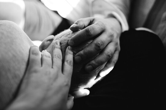 Two parent lay their hands on their child's head.