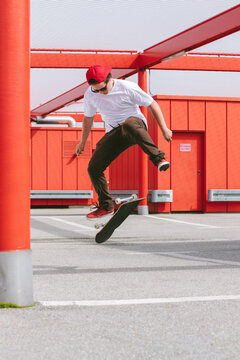 teenager in red urban area practicing skateboard tricks
