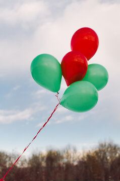red and green Christmas balloons against a winter landscape