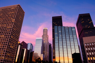Los Angeles skyline at sunset with brilliant pinks and purples reflecting in towering mirrored skyscrapers