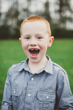 Portrait of a cute young boy smiling with a missing tooth in a f