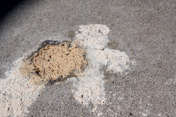 Filled in mud jacking drilled holes in concrete pavement