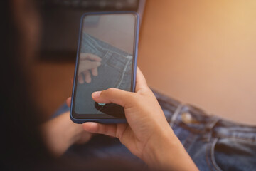 Clothing business owner is taking photos of their products to be upload to their online store website. Electronic trading model that allows consumers to shop directly on the internet concept.