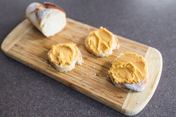 plant-based food, vegan snack with paprika hummus on sliced baguette bread