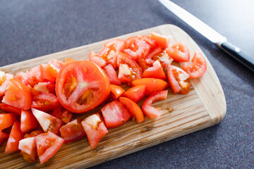 simple food ingredients, fresh raw tomatoes diced up on cutting board