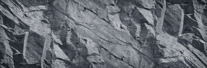 Black and white background. Old stone wall. Mountain surface texture. Close-up. Gray rock background. Baner with grunge texture for your design.