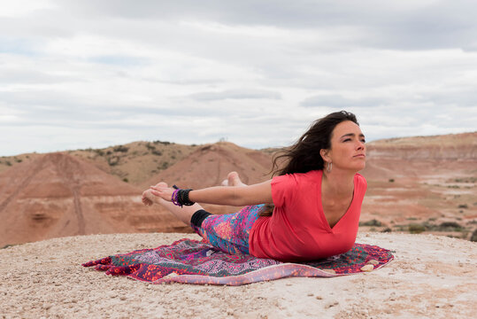 mujer practica yoga, en espacio natural.