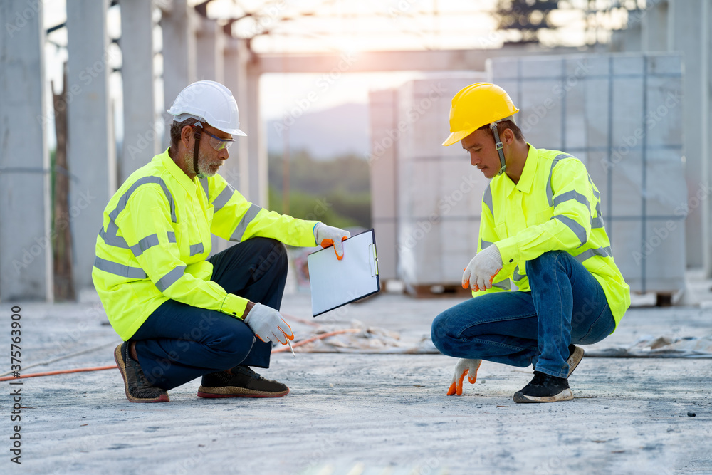 Poster two engineers in hardhats with clipboard and blueprint working at construction site,construction,bui