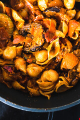 plant-based food, vegan eggplant zucchini and red pepper mix getting sauteed on a pan with mixed spices and red pesto pasta