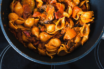 plant-based food, vegan eggplant zucchini and red pepper mix getting sauteed on a pan with mixed spices and red pesto pasta
