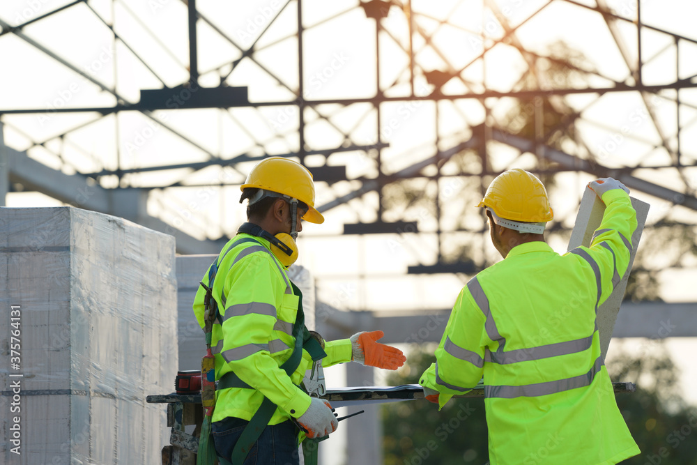 Poster two engineers in hardhats with clipboard and blueprint working at construction site,construction,bui