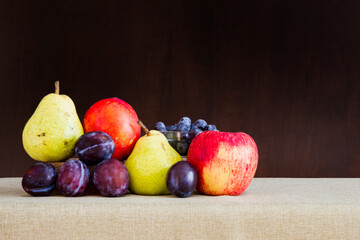 Still life of pear, plums, apple, blueberries and nectarine in a group; painting like effect of a bunch of fruit