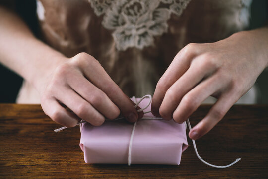 Hands gift wrapping a small present