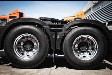 Naklejka na ściany i meble New a large truck wheels and tires of semi truck on parking. Truck transportation.