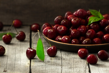 Still life with fresh cherries in a vase on the table.
