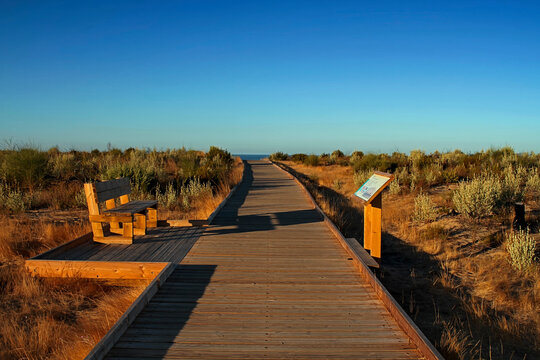 Wooden path on the sand in front of the sea in Cuesta Maneli photographed at sunrise, within the Do&ntilde;ana National Park, Huelva, Spain