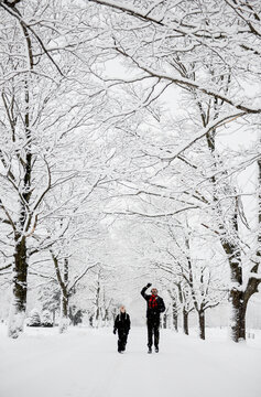 Boy and his dad laugh and catch snowflakes during a big snow