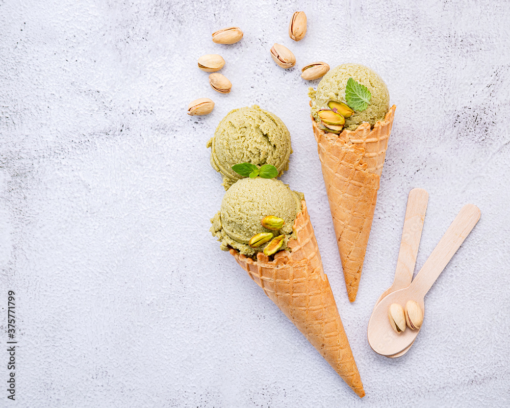 Poster pistachio ice cream in cones with pistachio nuts setup on white stone background . summer and sweet 