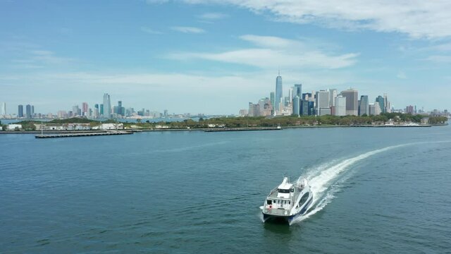 drone shot of ferry sailing away from Manhattan skyline