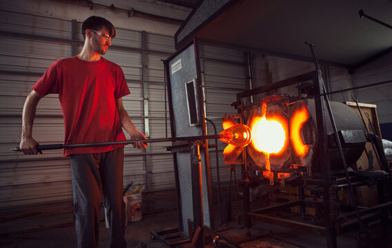 Glass: Man Uses Furnace to Reheat Glass Before Shaping