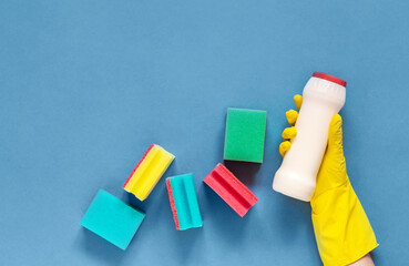 Woman's hand cleaning on a blue background.Cleaning or housekeeping concept background. Copy space. Flat lay, Top view.