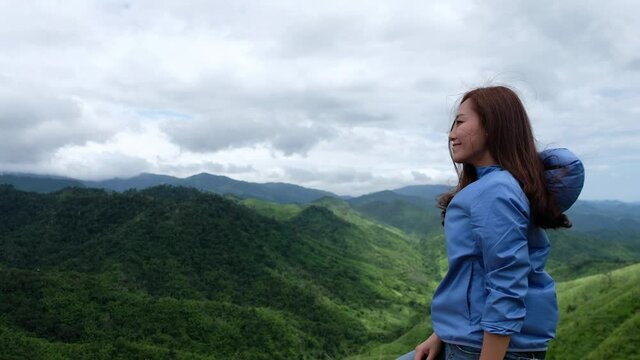 A female traveler looking at a beautiful green mountains view