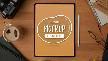 Mock up digital tablet on wooden table with stationery, supplies and a cup office beverage