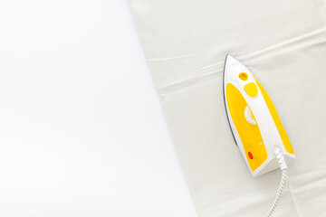 Household laundry ironing concept. Iron with clothes top view