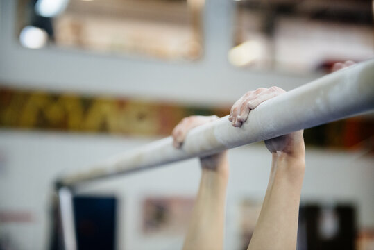 Child practices on the parallel bars in a gymnastics gym