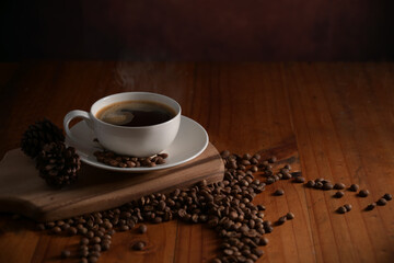Close up view of a cup of hot coffee on wooden tray decorated with coffee beans