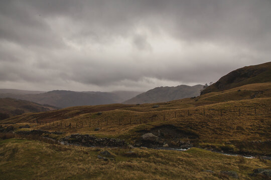 Dark clouds cover rolling hills