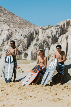 A group of friends hanging out on a beach waiting to hit the surf