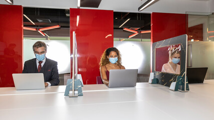 Business workers from different ethnicities and genders wearing face mask and support each other in...