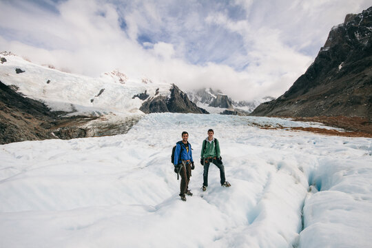 Two friends hiking with ice crampons a glacier