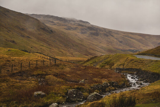 Dark clouds cover rolling hills