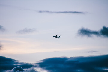 Airplane silhouette on sky with clouds
