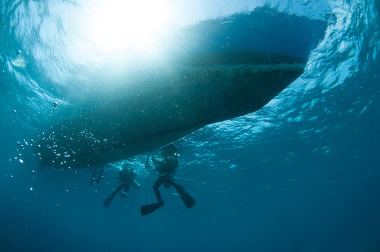 Scuba Divers and boat from below looking up