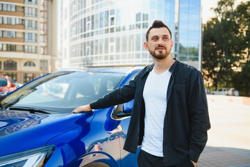 Test drive for auto. Pleasant overjoyed handsome boy holding steering wheel and driving his car while expressing gladness