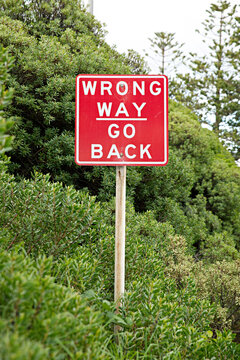 Wrong Way Go Back Sign In Bushes