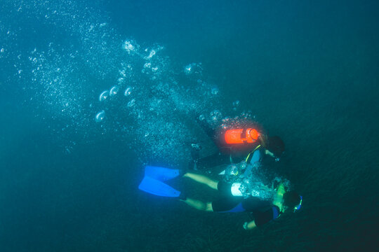 Scuba Divers diving deep underwater