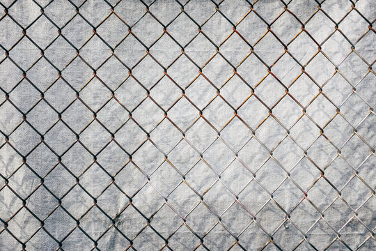 Chainlink fence in front of silver tarp