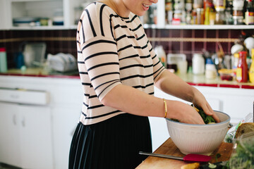 Tossing salad in the kitchen.